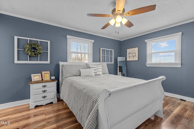 bedroom with ornamental molding, dark wood-type flooring, and ceiling fan