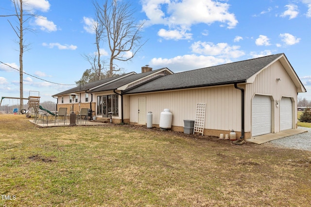 rear view of house featuring a garage, a patio, and a yard