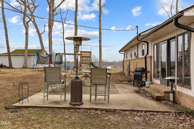 view of patio / terrace featuring a grill, a playground, and a trampoline