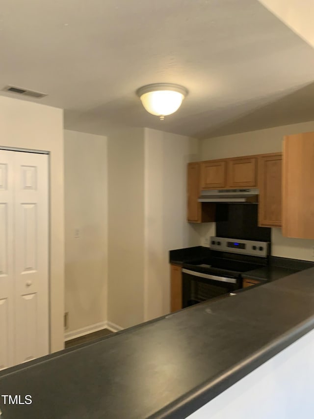 kitchen with stainless steel electric range oven, dark countertops, visible vents, and under cabinet range hood