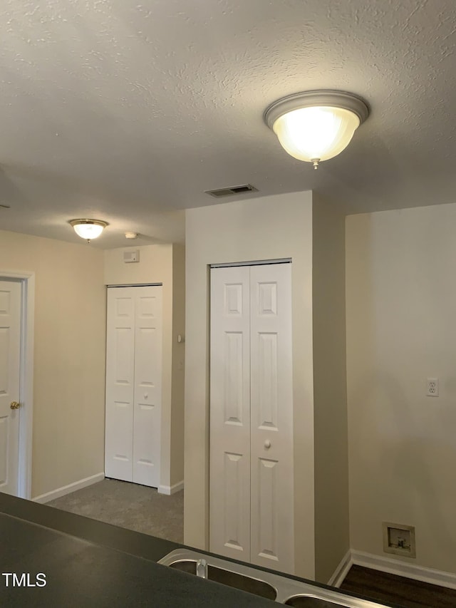 unfurnished bedroom featuring a textured ceiling, a closet, visible vents, and baseboards