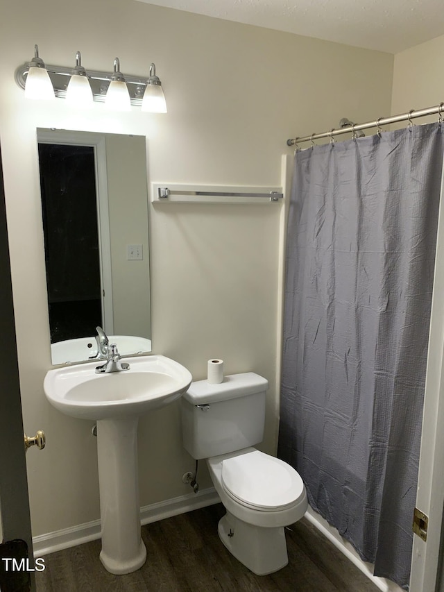 full bathroom with a shower with curtain, baseboards, toilet, and wood finished floors