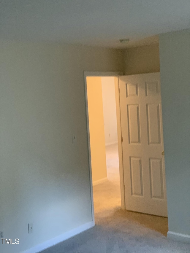 carpeted empty room featuring baseboards