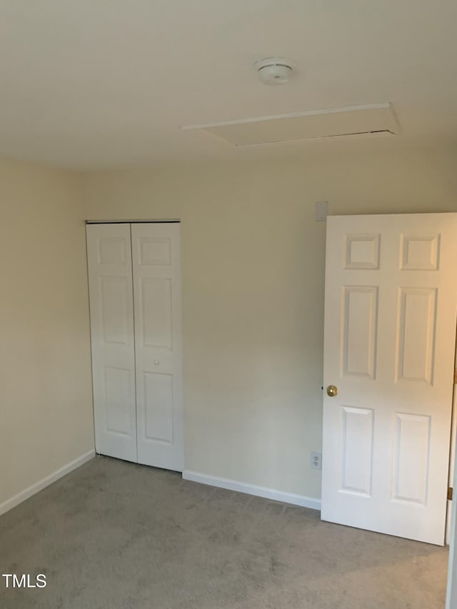 unfurnished bedroom featuring carpet, a closet, and baseboards