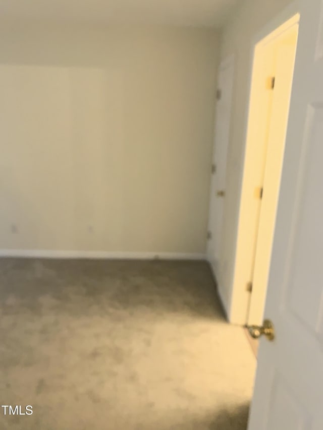 carpeted spare room featuring baseboards