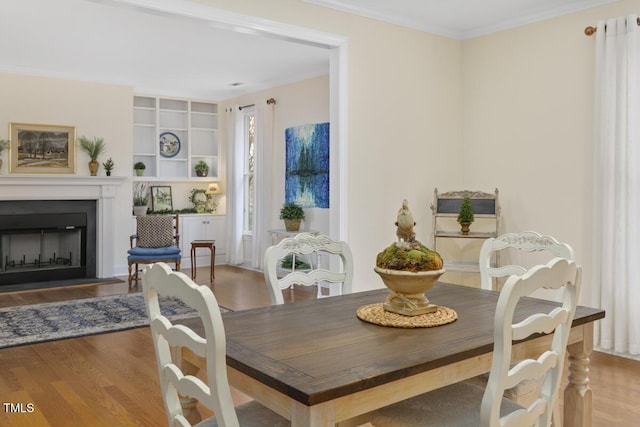 dining space featuring ornamental molding and light wood-type flooring