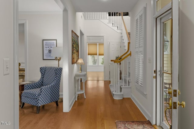 entryway featuring ornamental molding and light wood-type flooring