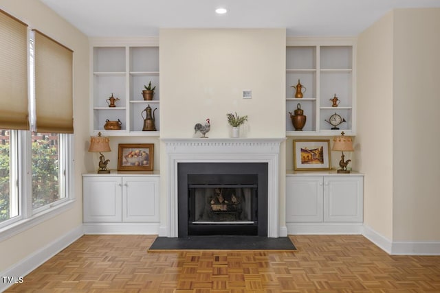 unfurnished living room featuring light parquet flooring and built in features