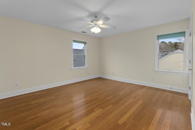 empty room featuring plenty of natural light, ceiling fan, and light hardwood / wood-style flooring