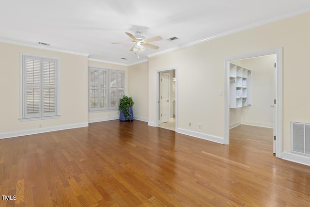 empty room with crown molding, ceiling fan, and wood-type flooring