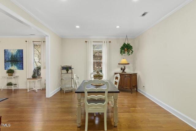 dining area featuring hardwood / wood-style flooring and ornamental molding