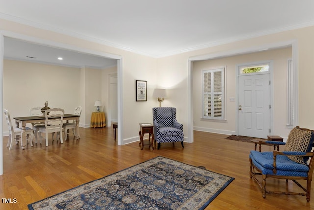 living area with ornamental molding and hardwood / wood-style floors