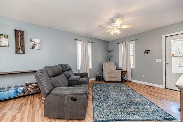 living room with hardwood / wood-style floors, a textured ceiling, and a healthy amount of sunlight