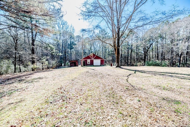 view of yard featuring a garage and an outbuilding