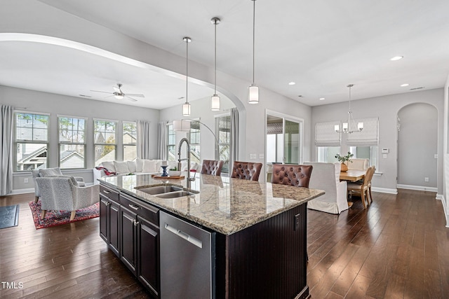 kitchen featuring a sink, light stone counters, open floor plan, dark wood finished floors, and dishwasher