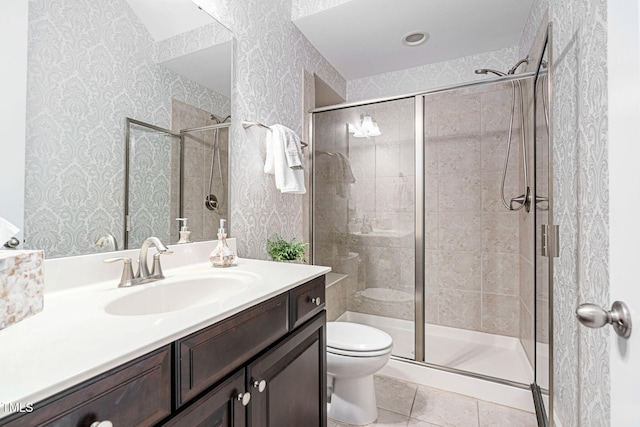 full bath with wallpapered walls, toilet, vanity, and a stall shower