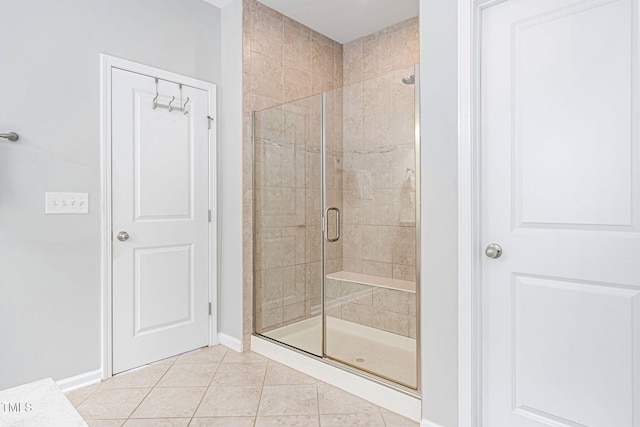 bathroom featuring tile patterned floors, baseboards, and a stall shower