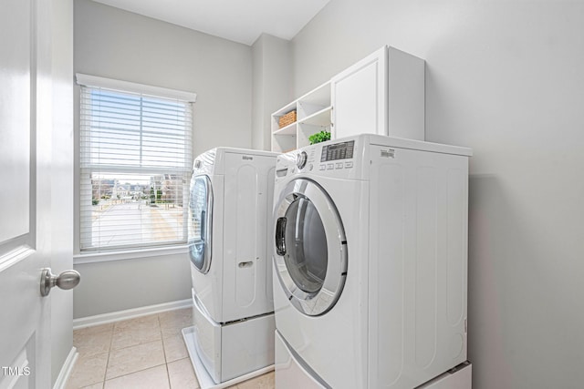 laundry room with washing machine and clothes dryer, laundry area, baseboards, and light tile patterned floors