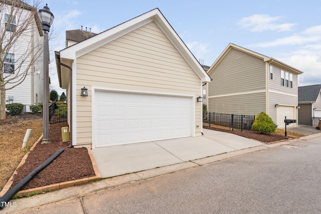 view of home's exterior with fence and a garage