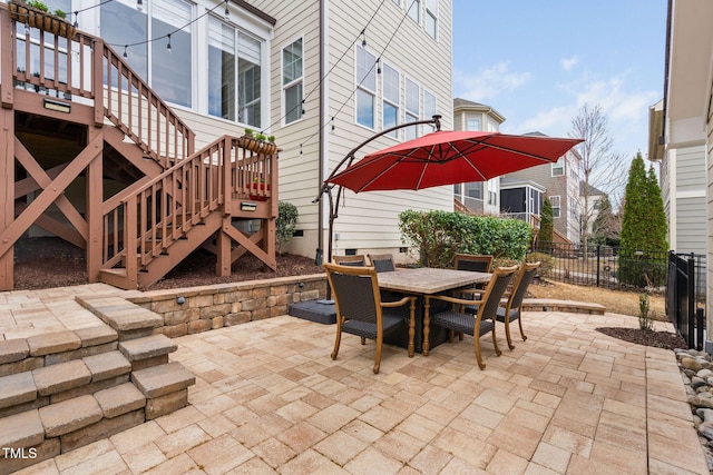 view of patio / terrace with stairway, outdoor dining area, and fence