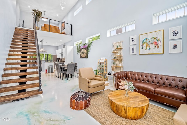 living area with recessed lighting, concrete floors, and a high ceiling