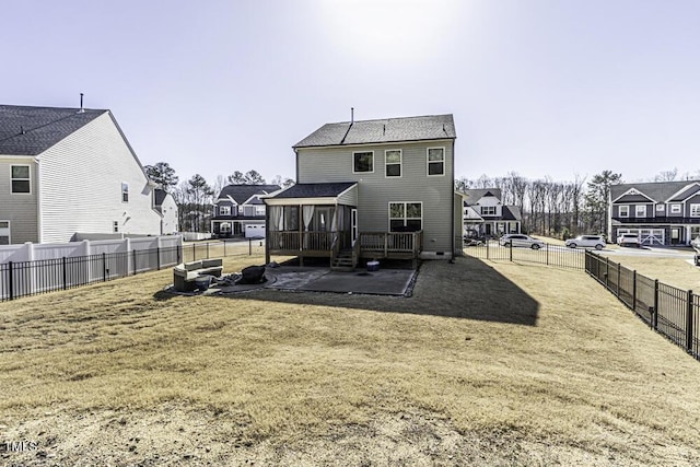 rear view of property with a lawn, a sunroom, and a patio area