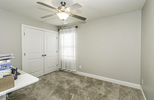 unfurnished office featuring carpet and ceiling fan