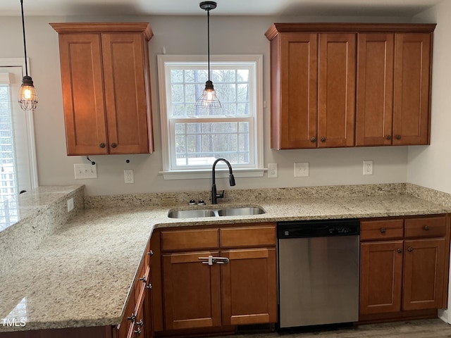 kitchen featuring light stone countertops, sink, stainless steel dishwasher, and decorative light fixtures