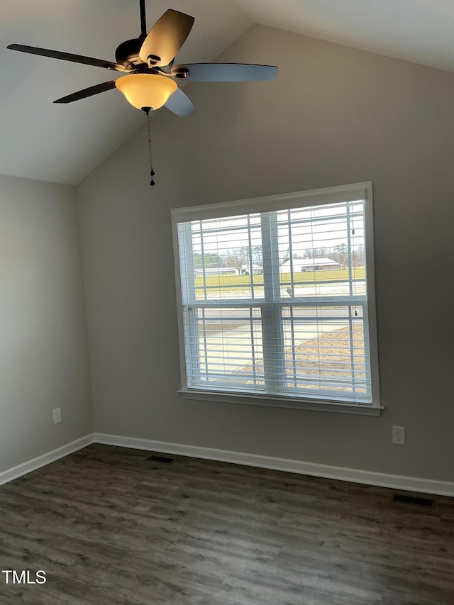 unfurnished room with vaulted ceiling, dark wood-type flooring, a wealth of natural light, and ceiling fan