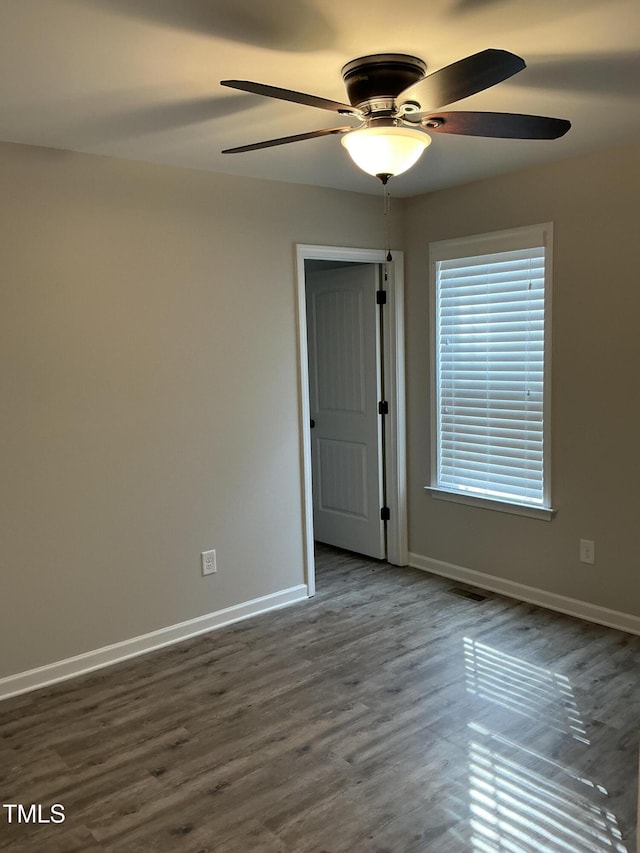 empty room with dark wood-type flooring and ceiling fan