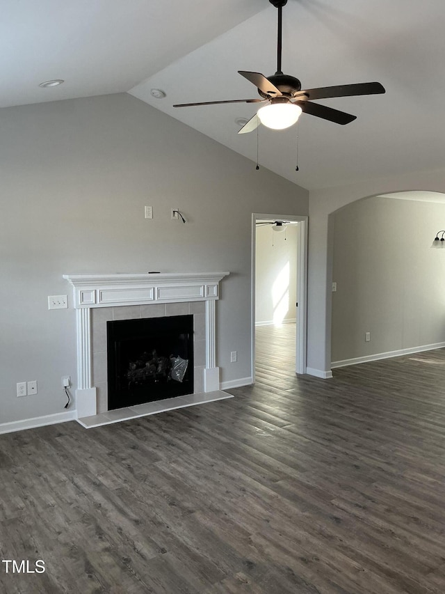 unfurnished living room featuring ceiling fan, a fireplace, dark hardwood / wood-style flooring, and vaulted ceiling