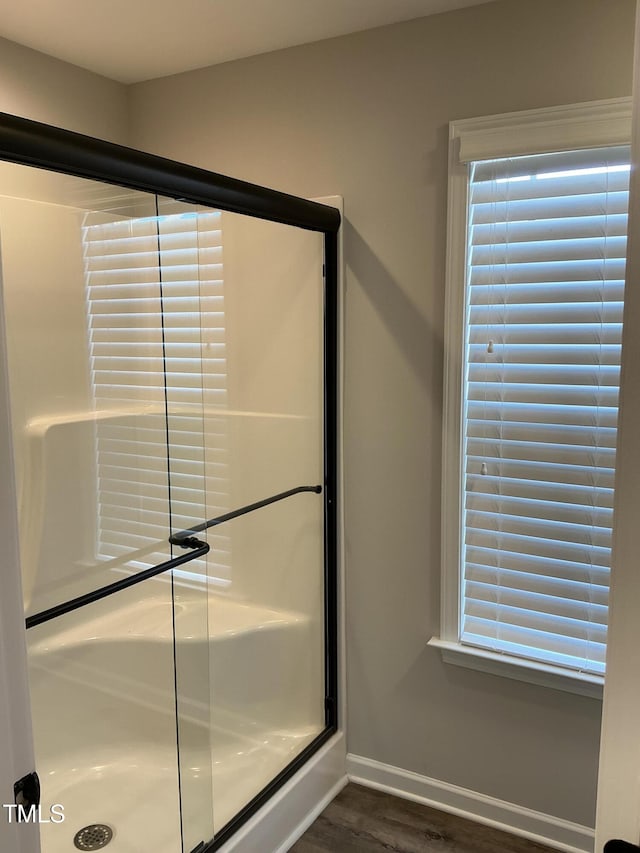 bathroom with an enclosed shower and hardwood / wood-style floors