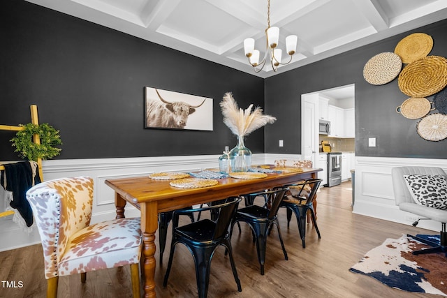 dining space featuring beam ceiling, coffered ceiling, a chandelier, and light hardwood / wood-style flooring