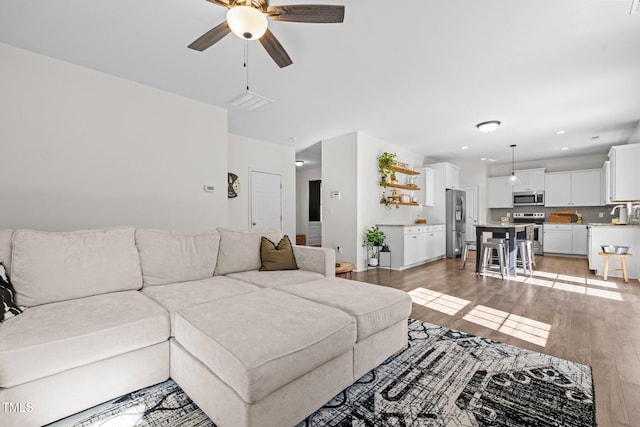 living room featuring ceiling fan and light hardwood / wood-style flooring