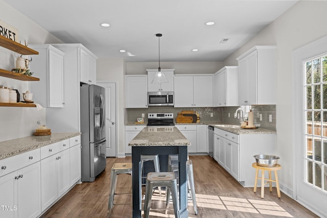 kitchen with white cabinetry, appliances with stainless steel finishes, a breakfast bar, and sink