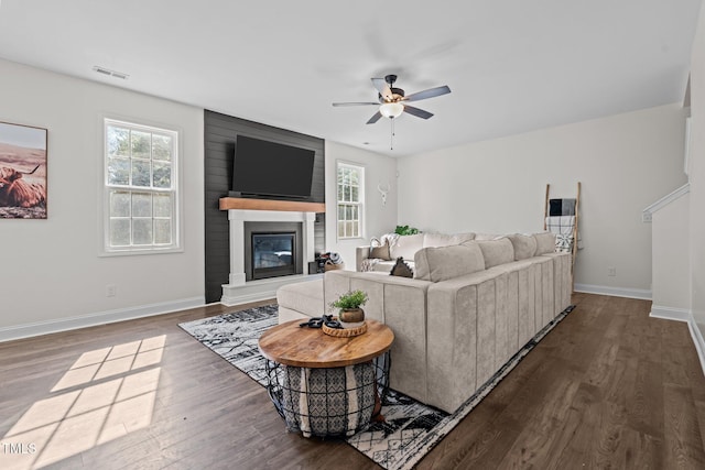 living room featuring a fireplace, wood-type flooring, and plenty of natural light