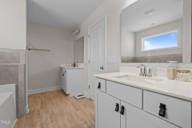 bathroom with vanity, hardwood / wood-style floors, and a bathing tub