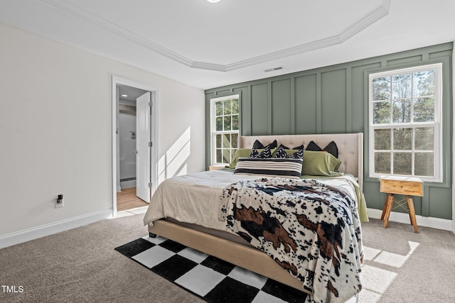 carpeted bedroom featuring a raised ceiling, crown molding, and a baseboard radiator