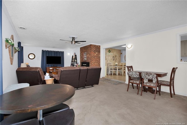 carpeted dining room with ceiling fan, ornamental molding, and a textured ceiling