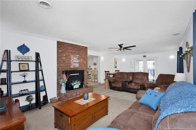 carpeted living room featuring crown molding, a brick fireplace, a textured ceiling, and french doors