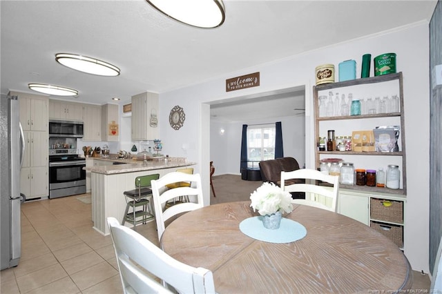 dining space featuring ornamental molding and light tile patterned floors