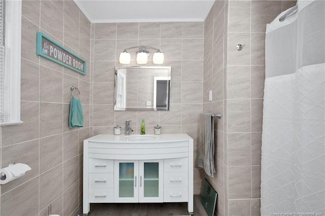 bathroom featuring vanity and tile walls