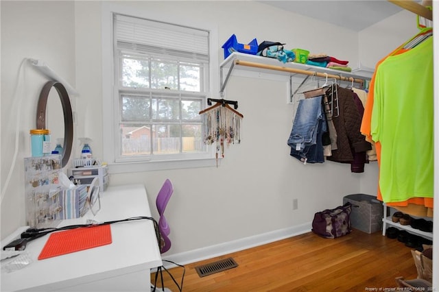 walk in closet with hardwood / wood-style floors