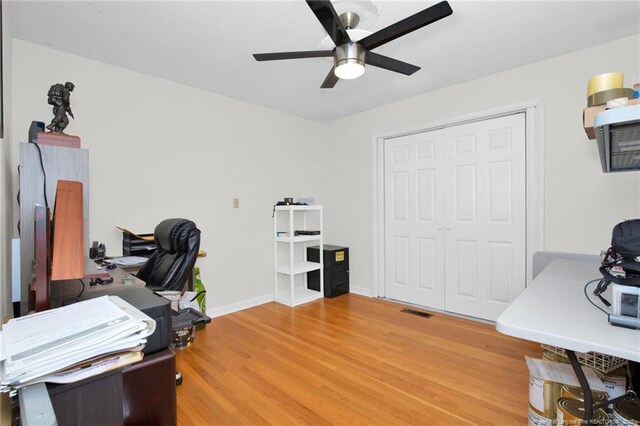 home office featuring hardwood / wood-style floors and ceiling fan