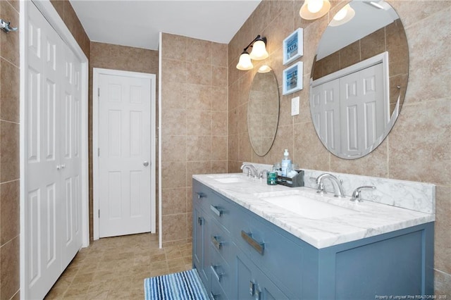 bathroom featuring tile patterned flooring, vanity, and tile walls