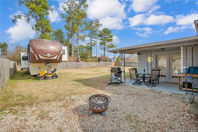 view of yard with a patio area, french doors, and an outdoor fire pit