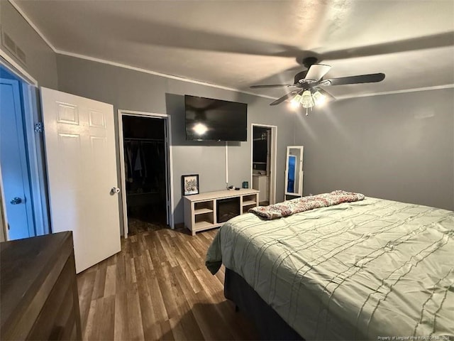 bedroom with crown molding, dark hardwood / wood-style floors, and ceiling fan