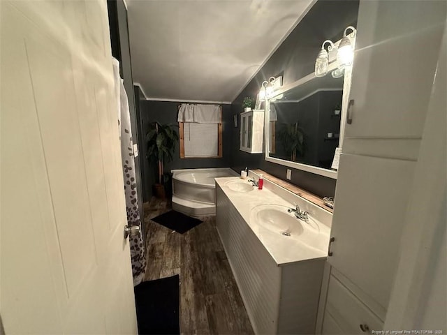 bathroom with vanity, a tub to relax in, and wood-type flooring