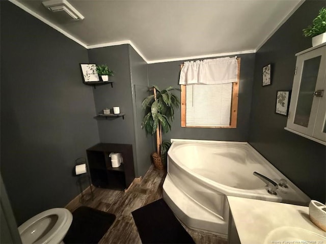 bathroom with crown molding, a tub to relax in, hardwood / wood-style floors, and vanity