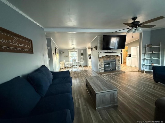 living room with a stone fireplace, wood-type flooring, lofted ceiling, ornamental molding, and ceiling fan